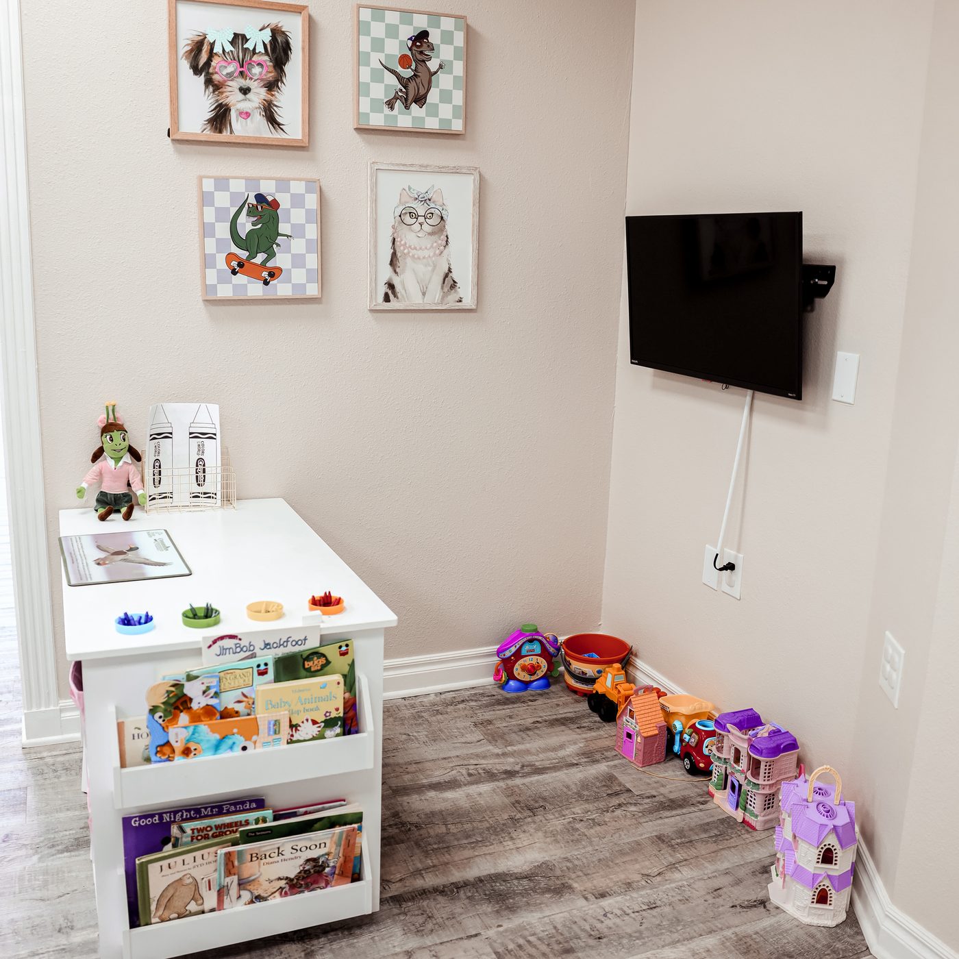 Kids' play corner at Eye Koni Optical with framed pet illustrations, toys, books, and a craft table
