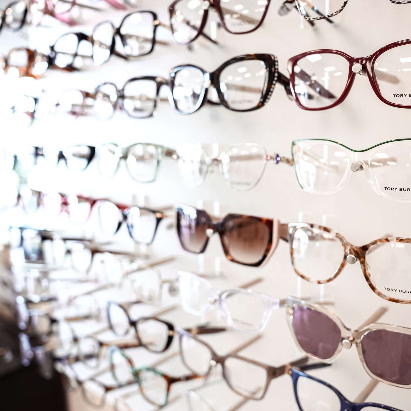 Designer women's prescription frames on display at Eye Koni Optical, including tortoiseshell acetate